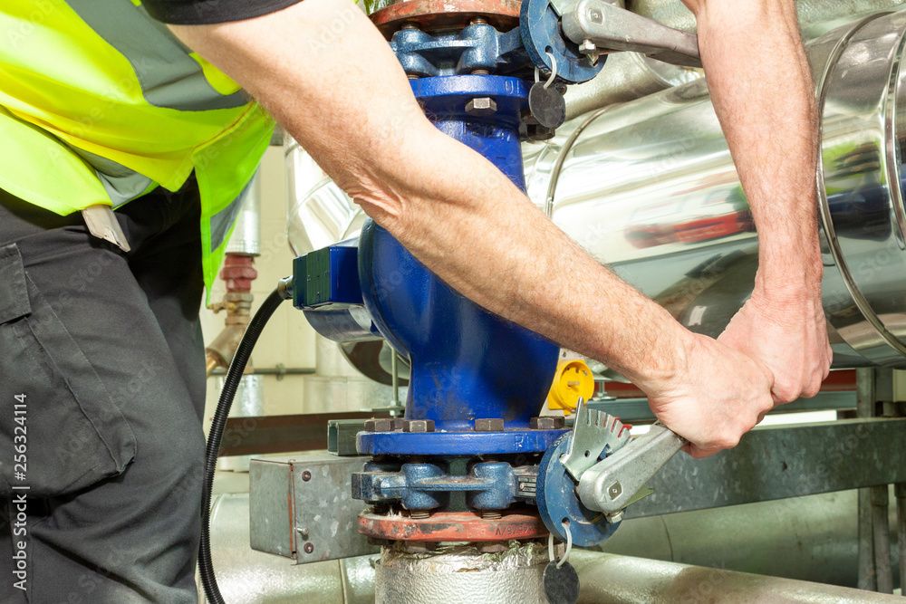 Mechanical engineer in high visibility vest opperating a valve Mechanical engineer in high visibility vest opperating a valve