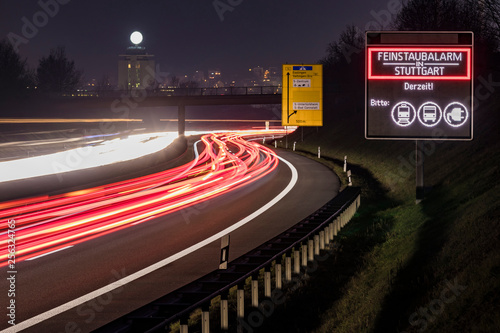 Germany, Stuttgart, Warning sign for particulate pollution alert and traffic at night