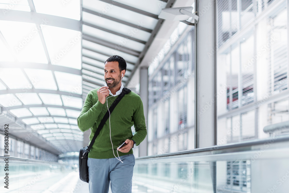 Businessman using smartphone on moving walkway Businessman using smartphone on moving walkway