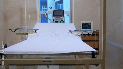 Fully-equipped hospital ward with empty bed. Empty hospital room with medical equipment. Burn center, clinic, hospital. First aid room in the hospital. Medical equipment. Postoperative ward. photo