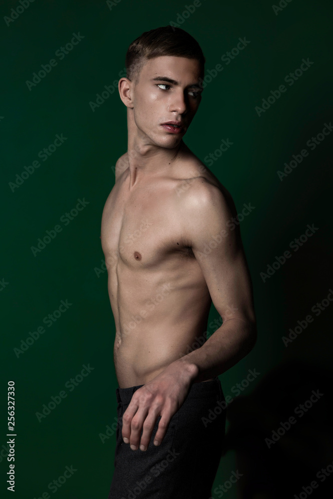 Half-naked young man in studio turning round