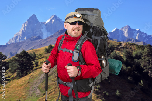 Happy male tourist with backpack is traveling in the highlands