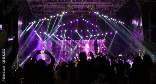 Group of people in outdoor concert, illuminated stage, high technology, powerful sound, latin america, fun, work, latin america.
