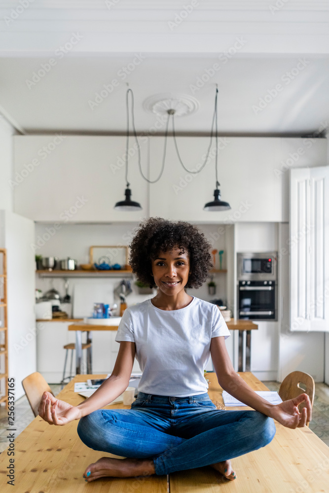 Portrait of smiling woman in yoga pose on table at home Portrait of smiling woman in yoga pose on table at home