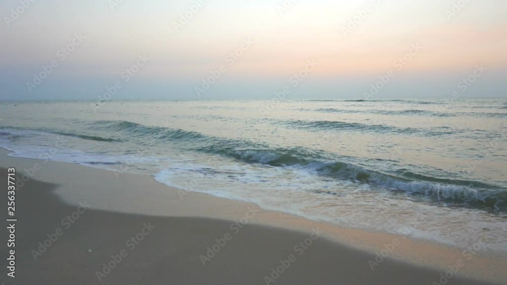 A pink sunset reflects in the incoming tide onto a white sandy beach. A pink sunset reflects in the incoming tide onto a white sandy beach.