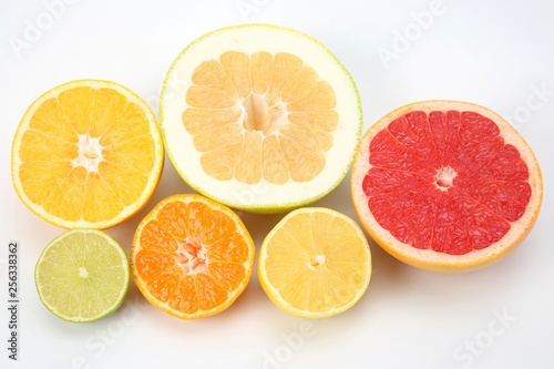 cut pieces of different citrus fruits on white background