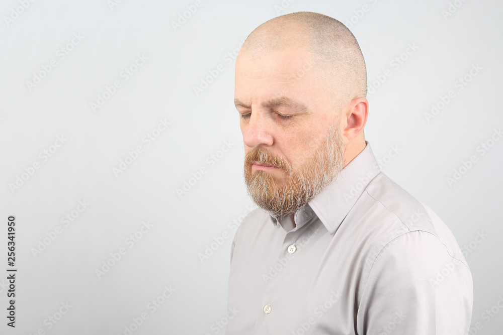 pensive bearded man in a shirt with your eyes closed