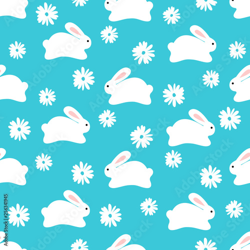 Seamless pattern of cute white bunnies on blue background with florwers photo