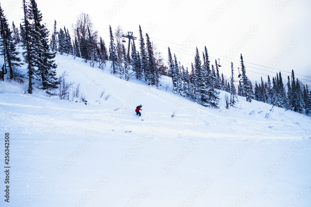 Snowboarder freerider in the mountains on a snowy slope.