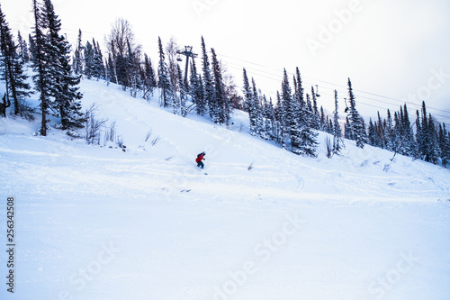 Snowboarder freerider in the mountains on a snowy slope.