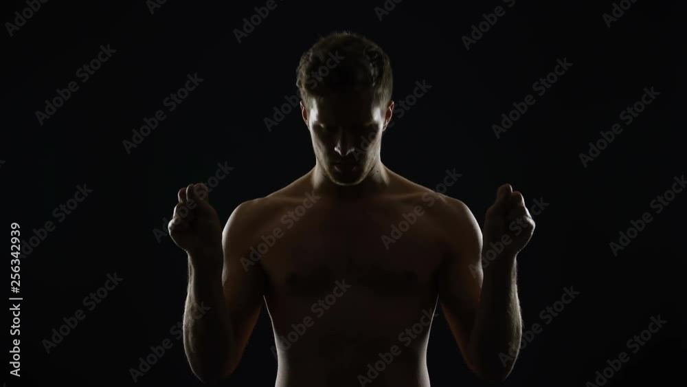 Male sportsman doing joint gymnastics before training, warming up hands and neck Male sportsman doing joint gymnastics before training, warming up hands and neck