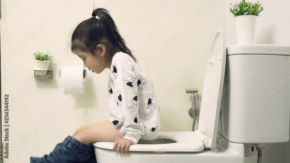 Little asian girl sitting on the flush toilet in the white bathroom and learning how to use the toilet by yourself, Teaching Your Child for Parents, KidsHealth Concept , Slow Motion footage Stock ビデオ | Adobe Stock 