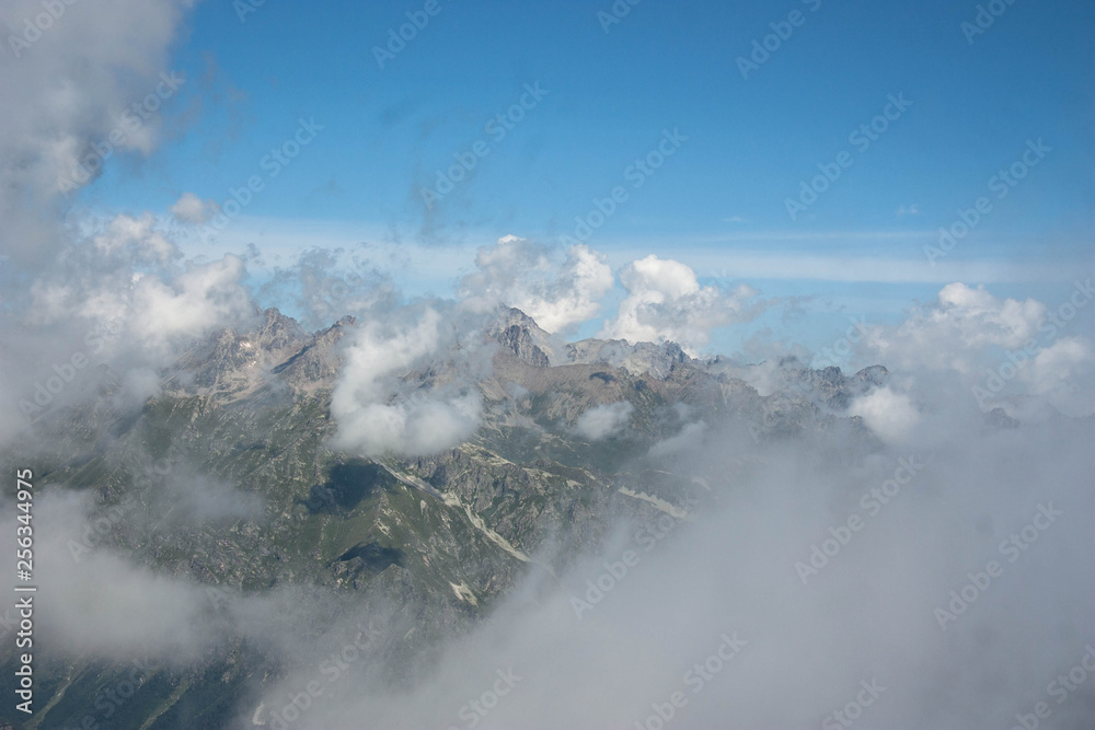 Fototapeta premium high steep mountains of the Caucasus above the clouds on a sunny day