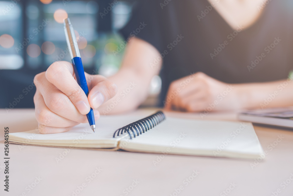 Woman hand is writing on a notebook with a pen. Woman hand is writing on a notebook with a pen.