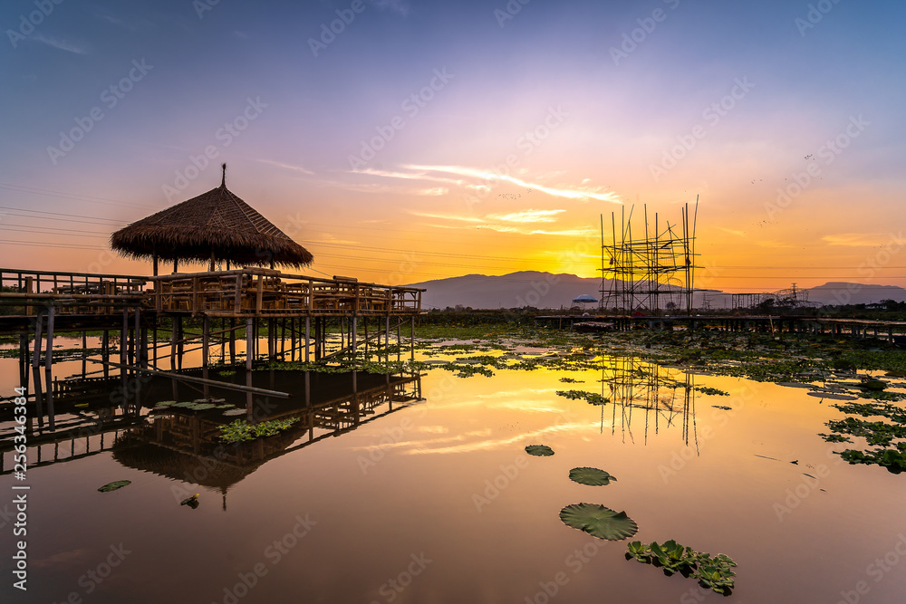 Twilight at the reservoir with silhouette bamboo pavilion and reflection in sunset, Chiang Mai in Thailand