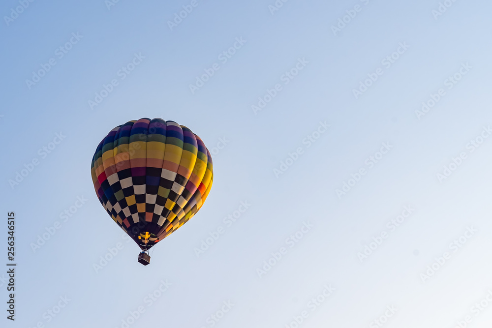 Hot air balloons flying on the blue sky during sunrise in morning. Hot air balloons flying on the blue sky during sunrise in morning.