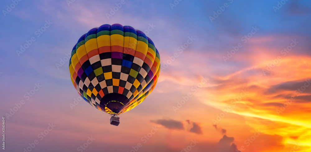 Obraz premium Hot air balloon flying during in colorful dramatic sky with cloud at sunset