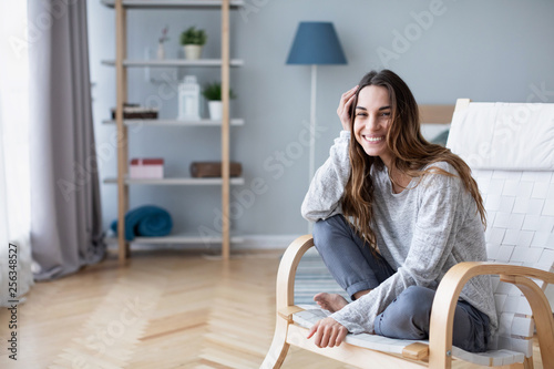 Home lifestyle woman relaxing on cozy chair in living room.
