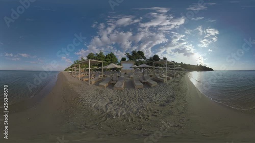 360 VR Video. Vacation scene. Sea skyline and beachline with rows of empty chaise-longues and sun umbrellas. Resort Trikorfo Beach in Greece photo