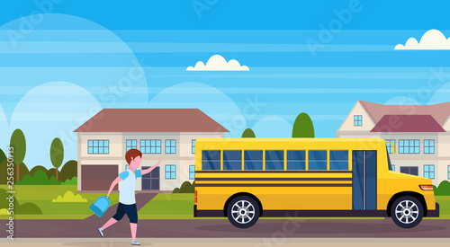 schoolboy running to chase yellow school bus pupils transport concept residential suburban street landscape background flat horizontal