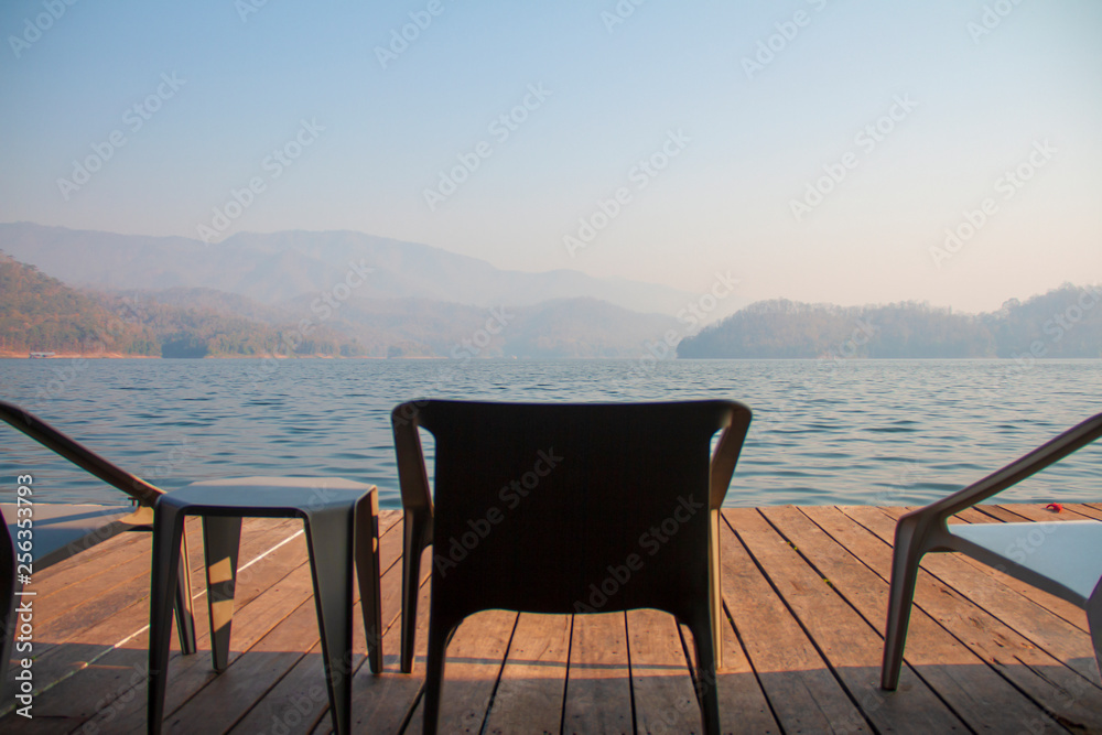 The chairs and table on the terrace of floating home stay for tourists to relaxing time or time of freedom. The mountain view in background.