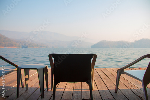 The chairs and table on the terrace of floating home stay for tourists to relaxing time or time of freedom. The mountain view in background.