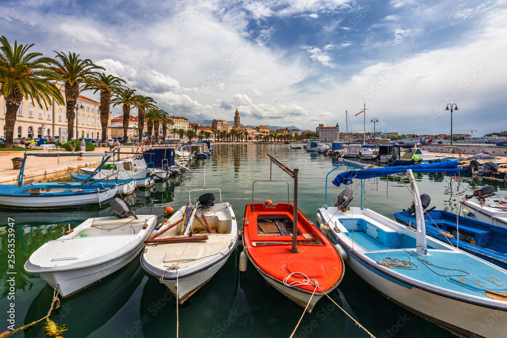 City of Split with colorful fishing boats in harbor, Dalmatia, Croatia. Waterfront view of fishing boats at mediterranean scenery in old roman town Split, Croatia.