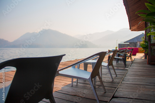 The chairs and table on the terrace of floating home stay for tourists to relaxing time or time of freedom. The mountain view in background.