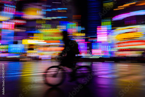 Photography motion blurred of rider ride bicycle with neon light background