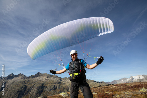 Closeup of a paraglider pilot balancing his paraglider above his head photo
