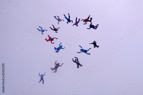 A group of skydivers is falling in the cloud.
