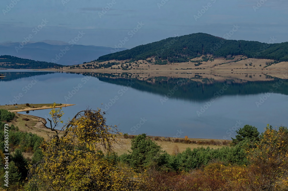 General view of Batak dam reservoir, coastal autumn glade, forest with reflection and hills at Rhodope mountains, Bulgaria  