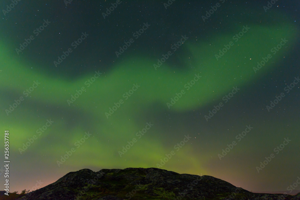 Green northern lights over the hills, aurora.