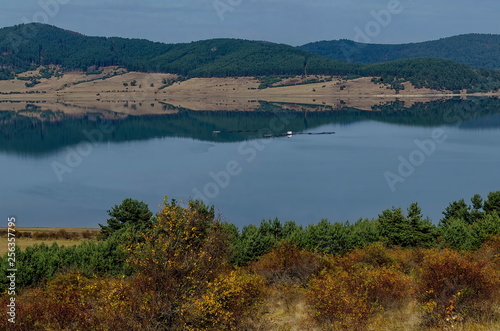 View of Batak dam reservoir, coastal autumn glade, forest with reflection and hills at Rhodope mountains, Bulgaria  © vili45