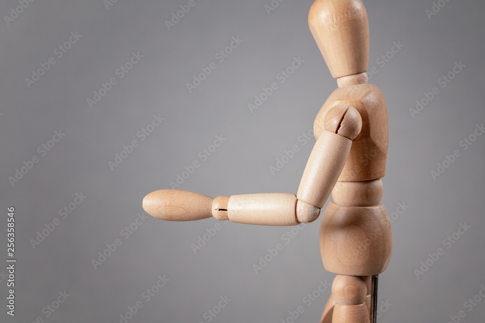 A wooden mannequin holds out his hand. A wooden mannequin holds out his hand.