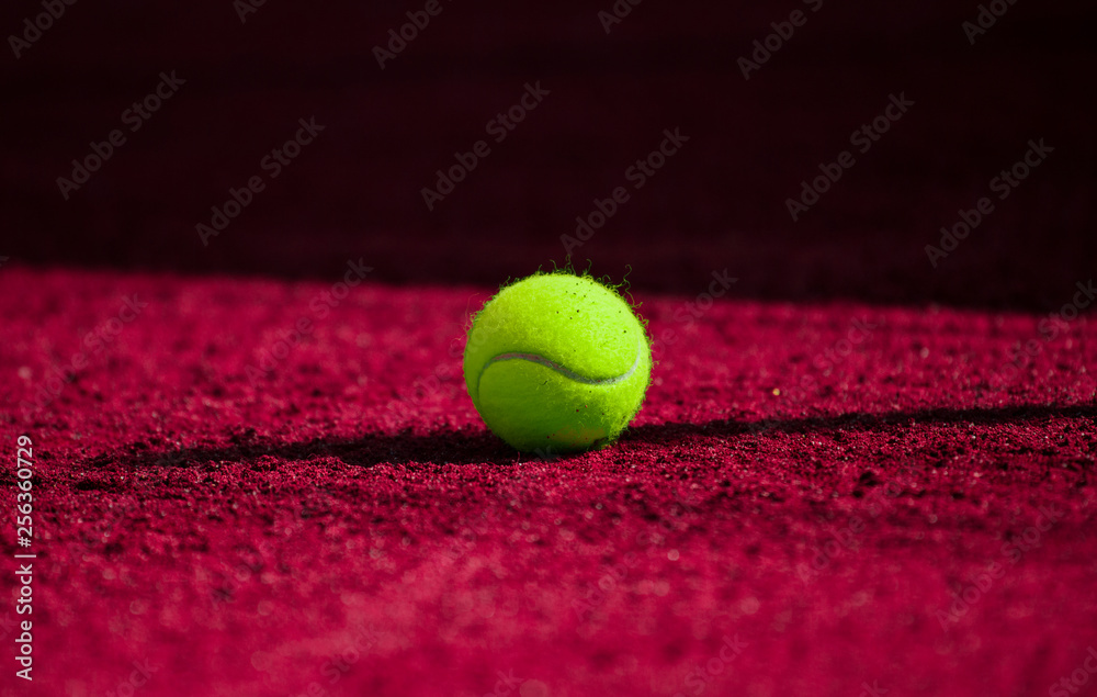 A lonely Tennis Ball on a Sand Court