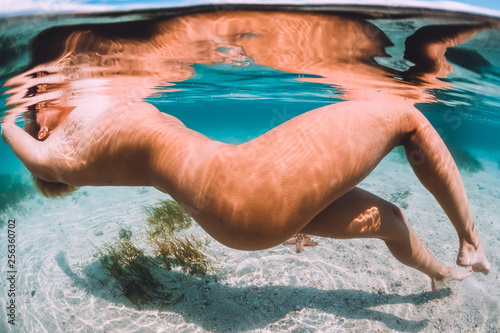 Photography Nude woman swimming with starfish, underwater photo in tropical ocean