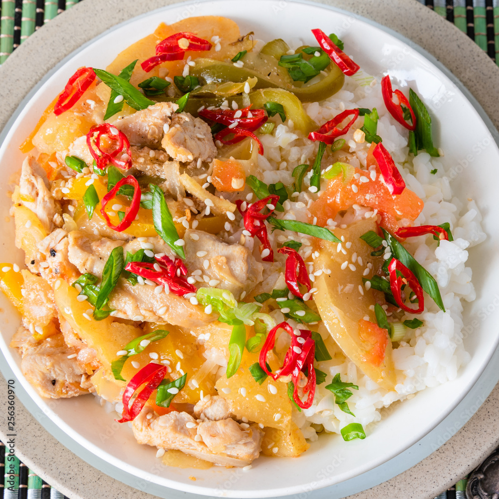 Chicken and apple curry with rice in a bowl and chopsticks, close-up - Asian cuisine. Chicken and apple curry with rice in a bowl and chopsticks, close-up - Asian cuisine.