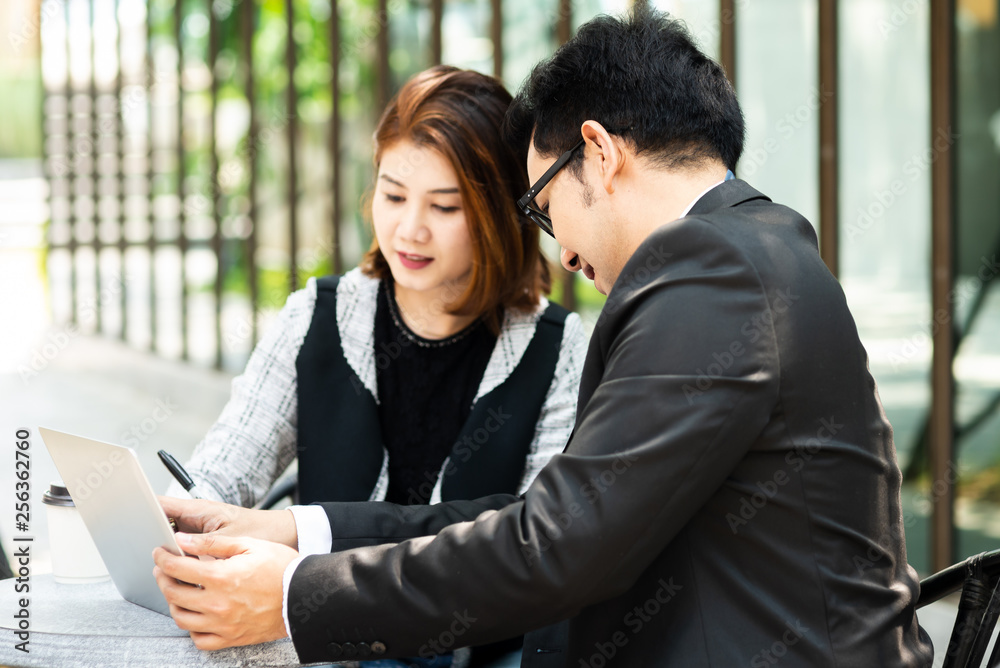 Business woman sitting at cafe outdoor and discussing with her team.