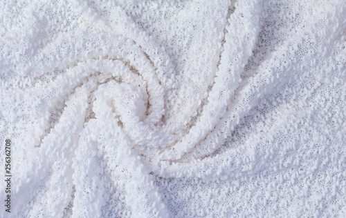 textured background of white fabric twisted into a spiral.the view from the top