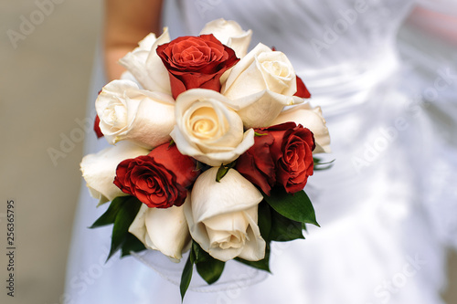 Bridal bouquet of red and white roses in the hand of the bride
