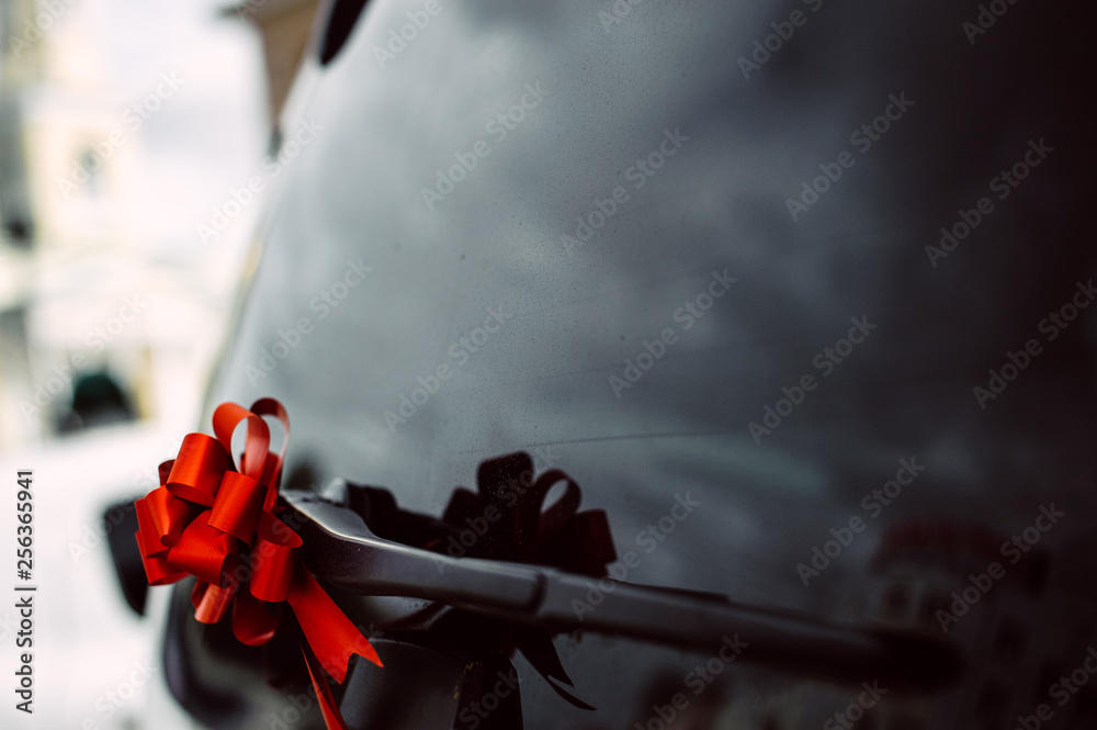 Fototapeta premium black car door handle decorated with red bow