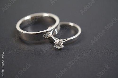 Close up two platinum diamond wedding rings isolated on black background.
