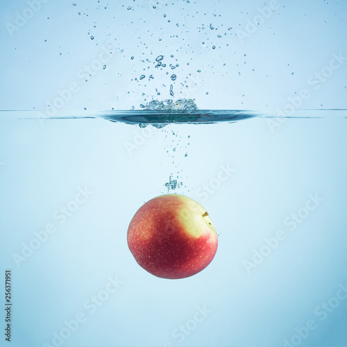 Fresh apple dropped in water with splash