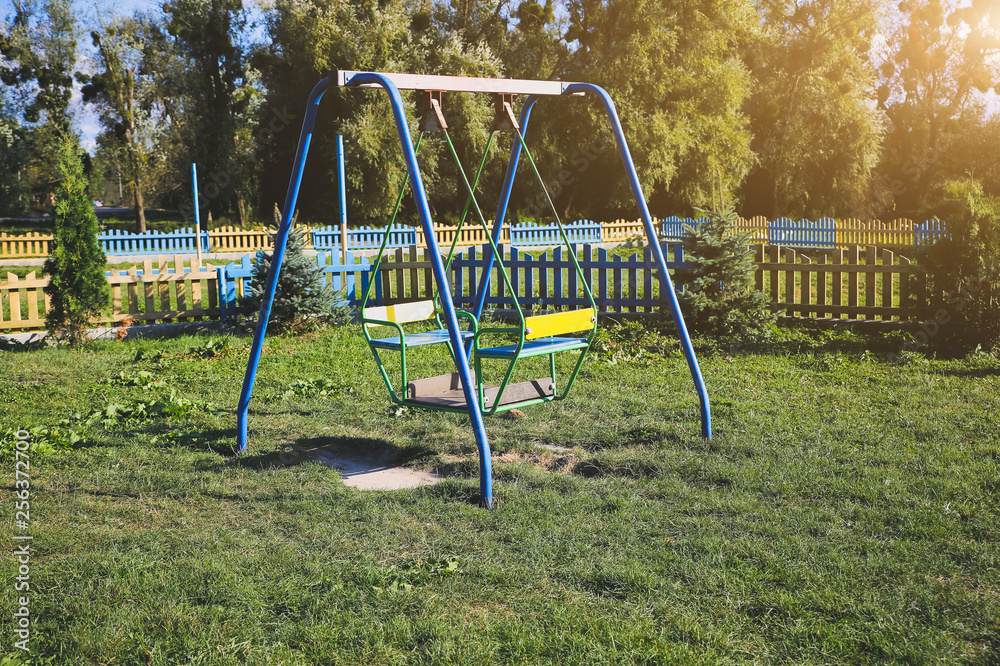 Two swings on children playground. Outdoors games for kids. Summer day. Two swings on children playground. Outdoors games for kids. Summer day.