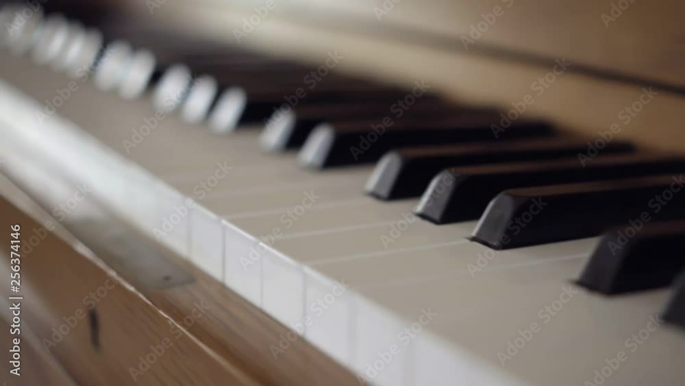 shallow depth of field focus over a black and white keys of a stand up cherry wood piano shallow depth of field focus over a black and white keys of a stand up cherry wood piano