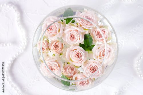 Round vessel with water and small peach roses.