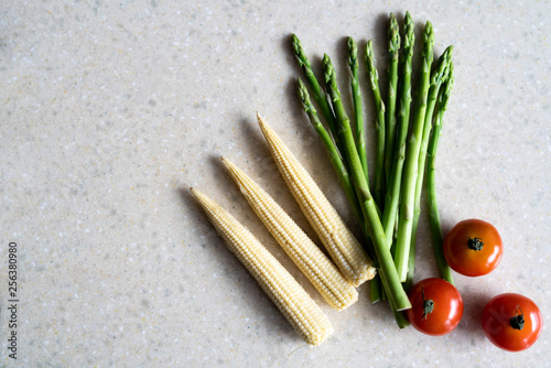 cherry tomatoes, asparagus, and corn on a light background