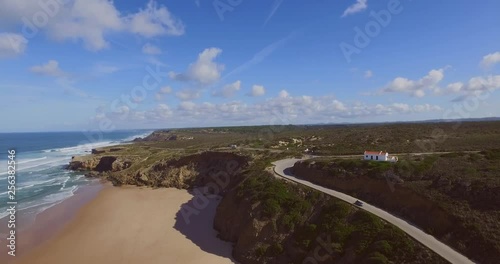 The town of Monte Clerigo with a car driving on the cliffs. Aerial shot.