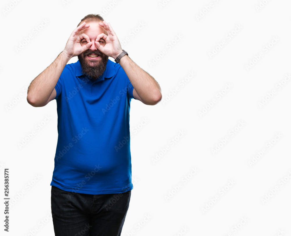 Young caucasian hipster man wearing blue shirt over isolated background doing ok gesture like binoculars sticking tongue out, eyes looking through fingers. Crazy expression. Young caucasian hipster man wearing blue shirt over isolated background doing ok gesture like binoculars sticking tongue out, eyes looking through fingers. Crazy expression.